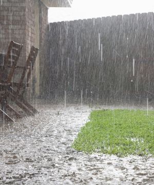 heavy downpour of rainfall and flooding in residential backyard
