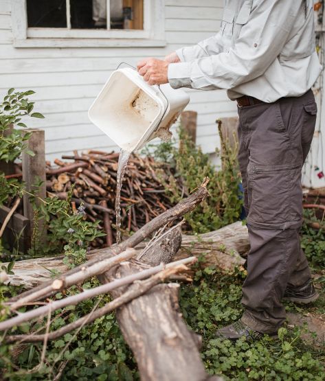 mosquito expert performing source reduction by emptying standing water from backyard container